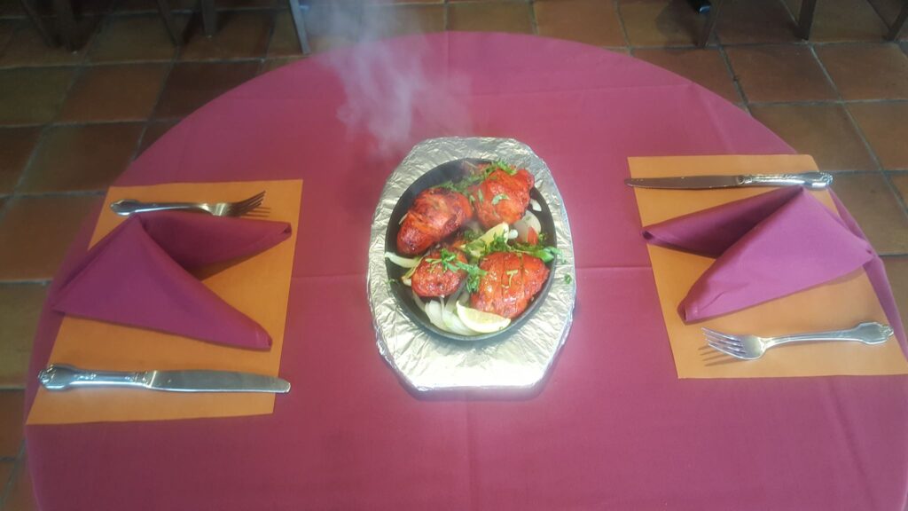 A sizzling tandoori platter on a table set for two